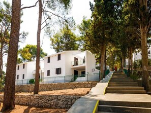Stunning building with a central entrance and symmetrical facade, surrounded by a tranquil garden.