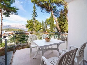 Enjoy a serene mountain view from this balcony, featuring a table and chairs.