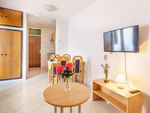 Relax in a comfortable living space with a flat-screen TV, dining area, and fully equipped kitchen.