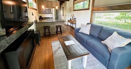 Luxury Accommodation. Bedroom with queen bed. Sleeper sofa in living area. Full bath with shower. Kitchen. Living area with TV and Fireplace. Washer/Dryer.