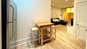 A compact living space with a kitchenette, a dining table, a sofa, and a television. - L'Ananas ~ A Charming Home in the Heart of Downtown (Québec)