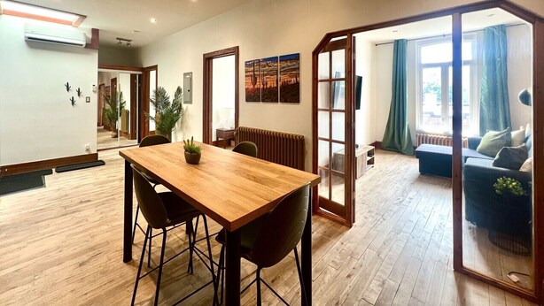 A spacious room with a wooden dining table, chairs, a radiator, and a sofa. - The Cactus ~ Superb accomodation in Saint-Roch, Downtown Quebec (Québec)