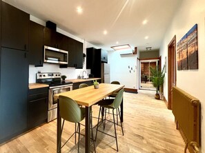 Une cuisine moderne équipée d’une table et de chaises, d’un four à micro-ondes et d’une cuisinière.