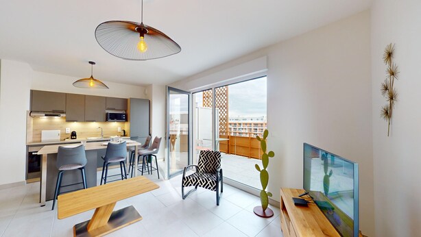 A modern apartment with a kitchen, dining area, and living room.