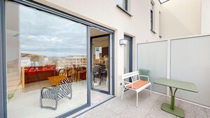 A modern apartment with a balcony, a dining area, and a small table.