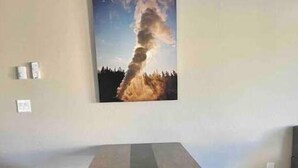 Una taula de fusta llarga amb potes metàl·liques en una habitació amb una paret senzilla i un quadre al seu damunt.