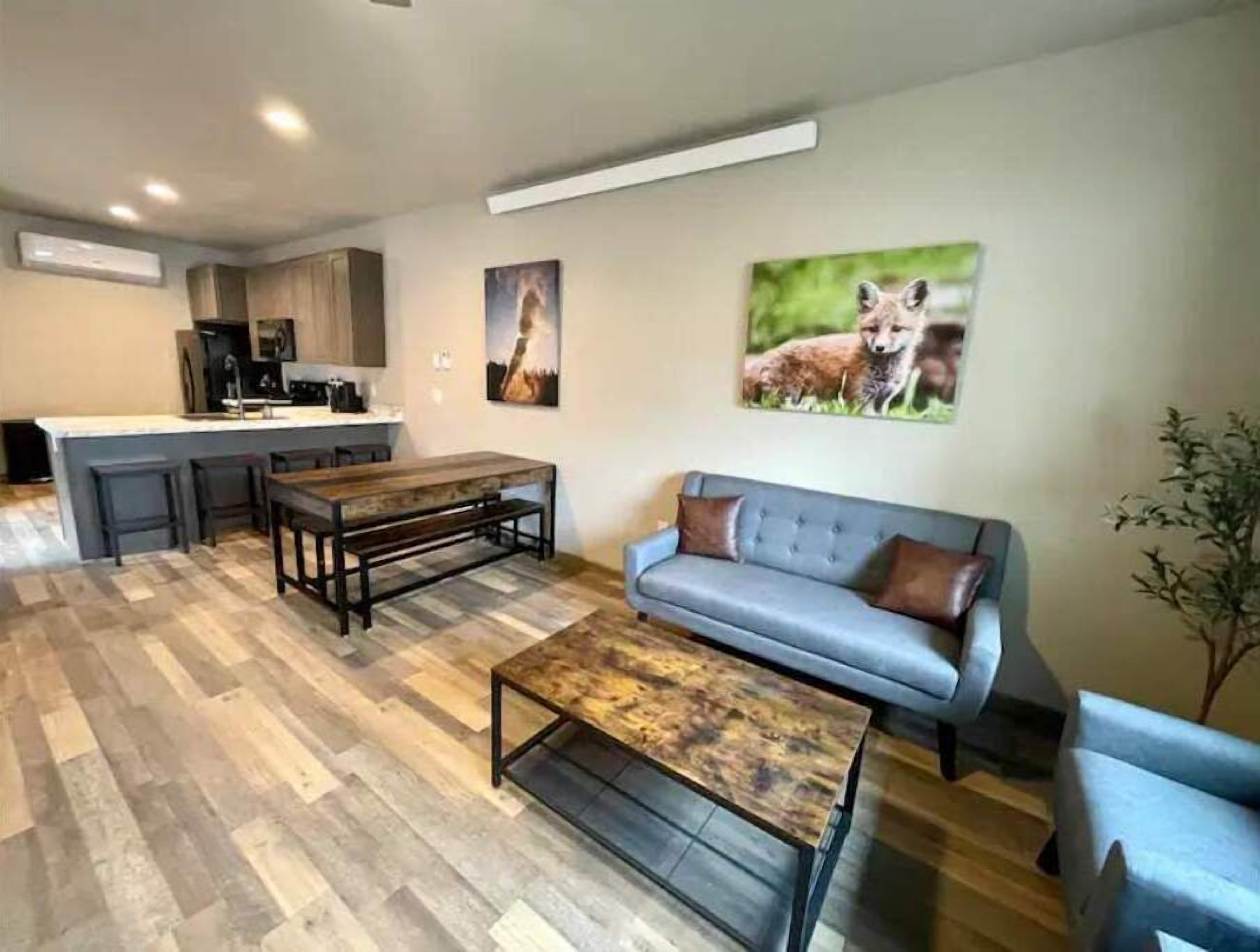 Ein modernes Wohnzimmer mit einer Couch, einem Couchtisch und einem Essbereich mit einer Bank.