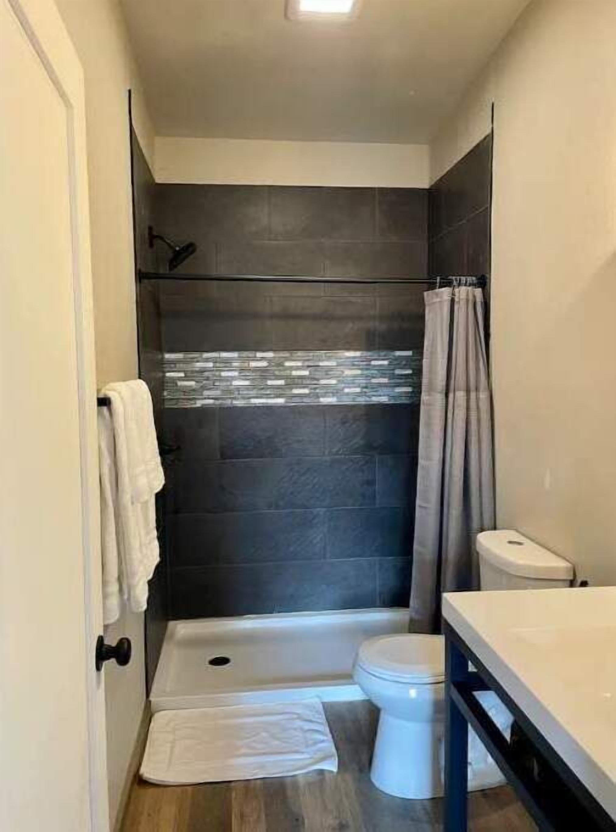 Un baño con ducha, inodoro y lavabo.