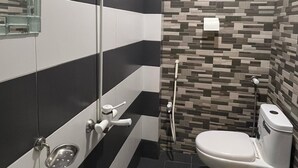 Un baño con un lavamanos grande, un inodoro y una zona de ducha.