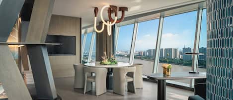 A modern dining area with a round table, six chairs, and a decorative centerpiece.