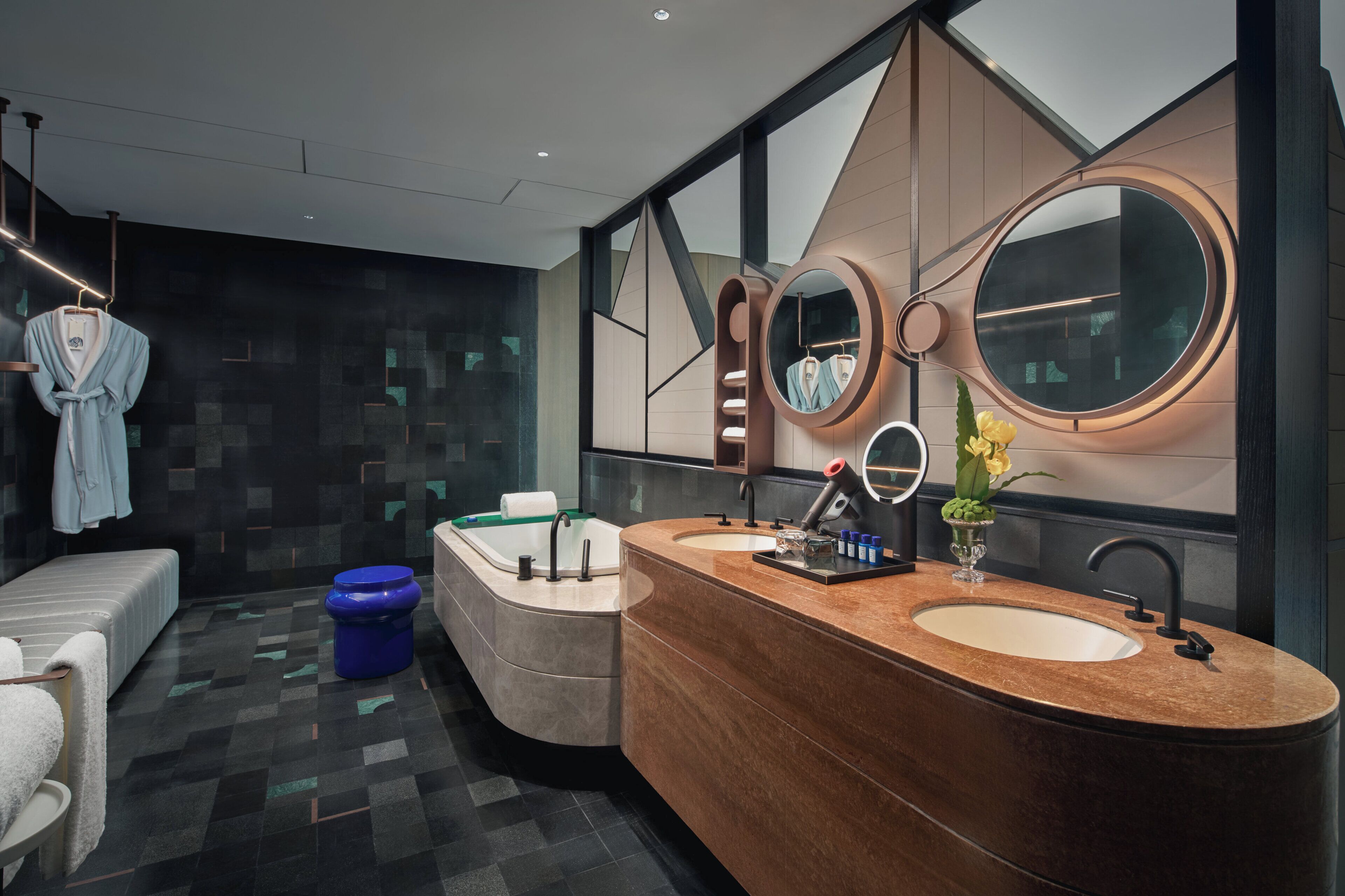A modern bathroom with a double sink vanity, a large mirror, and a bathtub.