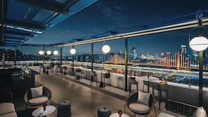A rooftop bar with outdoor seating, city views, and modern lighting. - Hotel Indigo Ningbo Riverside by IHG (Ningbo)