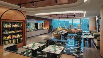 Een modern restaurant met een geruit vloerkleed, een fruitstelling en uitzicht op de stad.