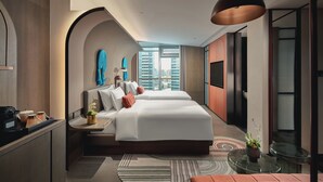 A modern hotel room with a large bed, a desk, a seating area, and a view of the city. - Hotel Indigo Ningbo Riverside by IHG (Ningbo)