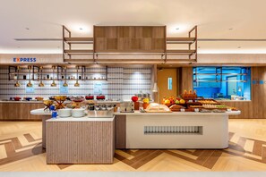 Una barra de desayuno moderna con diversas opciones de comida y una estación de café.