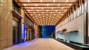 Un edificio moderno con un largo pasillo, iluminación empotrada y una fuente de agua.
