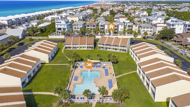 An aerial view of a resort with a swimming pool, multiple buildings, and a beach in the background. - 10G, Sandy´s Beach Retreat (Destin)