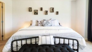 Une chambre à coucher bien rangée, avec un lit, des oreillers et une table de chevet.