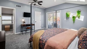 A bedroom with a bed, a desk, a chair, a ceiling fan, and a TV. - Hot Tub - N64 - Mins to Downtown - Sleeps 8 (Cleveland)