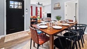 A modern dining area with a wooden table set for four, surrounded by black chairs. - Hot Tub - N64 - Mins to Downtown - Sleeps 8 (Cleveland)