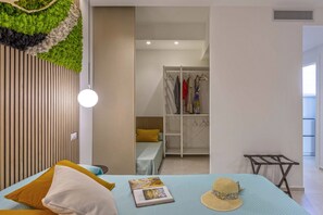 Relax in this serene bedroom with a plush bed, featuring a blue quilt and a variety of pillows, including a statement yellow one.