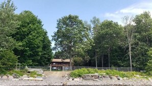 Eine Holzhütte an einem See, umgeben von Bäumen.