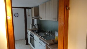 A compact kitchen with a sink, stove, and cabinets.