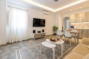 Suite Deluxe, vista al jardín | Área de sala de estar | Televisión de pantalla plana de 43 pulgadas con canales por cable 