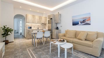 Deluxe suite, uitzicht op tuin | Woonruimte | Een 43-inch flatscreentelevisie met kabelzenders