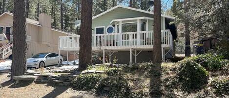 A cabin with a porch, surrounded by trees.