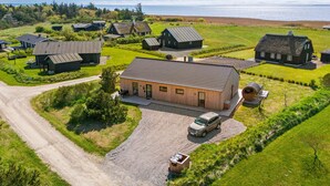 A rural property with multiple houses, a gravel driveway, and a car parked in front.