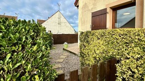 Il s'agit d'une propriété résidentielle dotée d'une allée pavée, d'une clôture en bois et d'une haie bien entretenue.