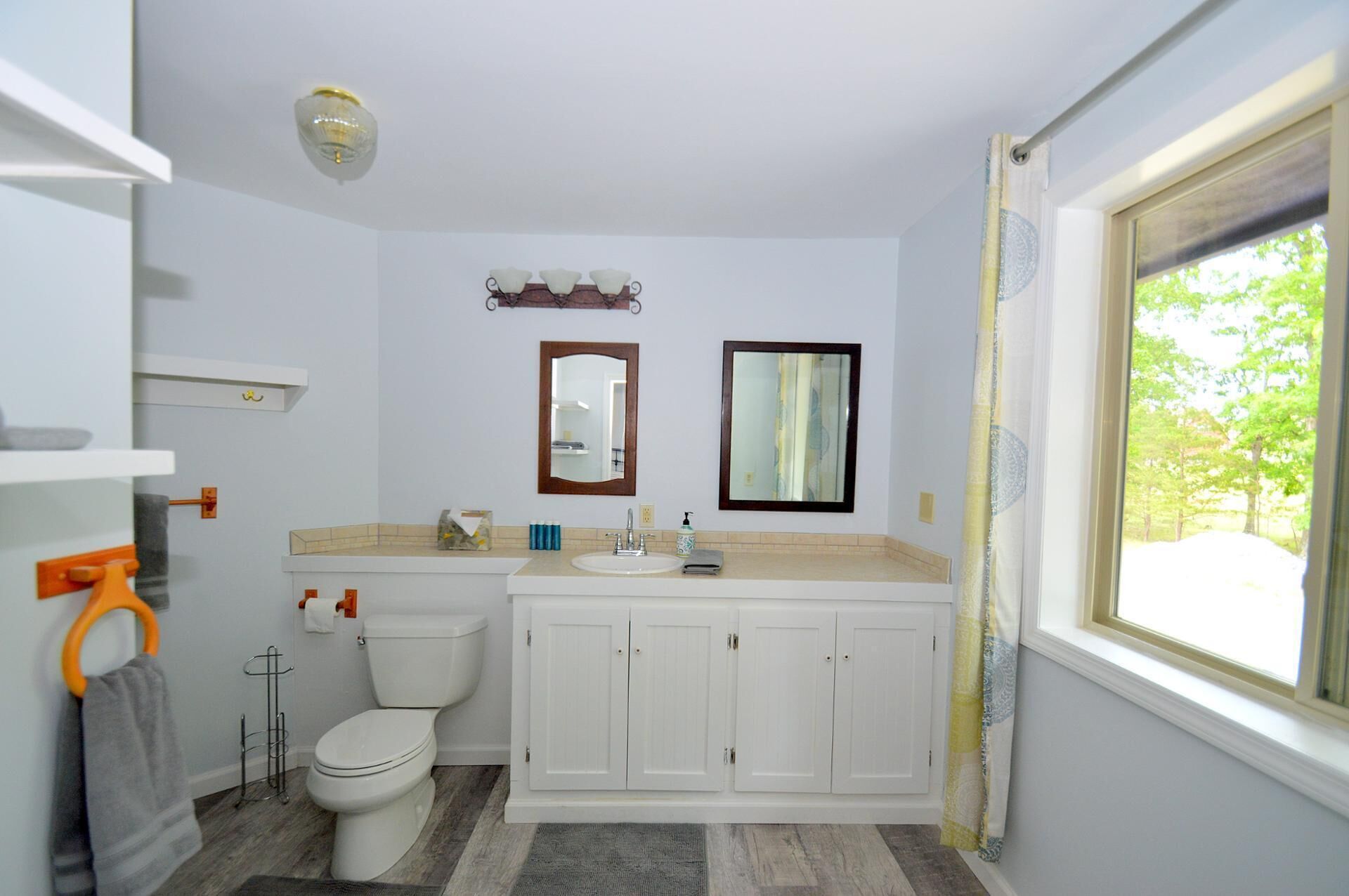 Un baño con inodoro, lavabo y armarios.