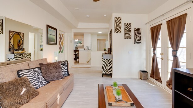 Ein geräumiges Wohnzimmer mit einer Couch, einem Couchtisch und Zebra-Dekoration.