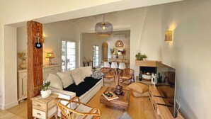 A spacious living room with a sofa, chairs, a coffee table, and a fireplace. - Lovely home in Nans-Les-Pins (Nans-Les-Pins)