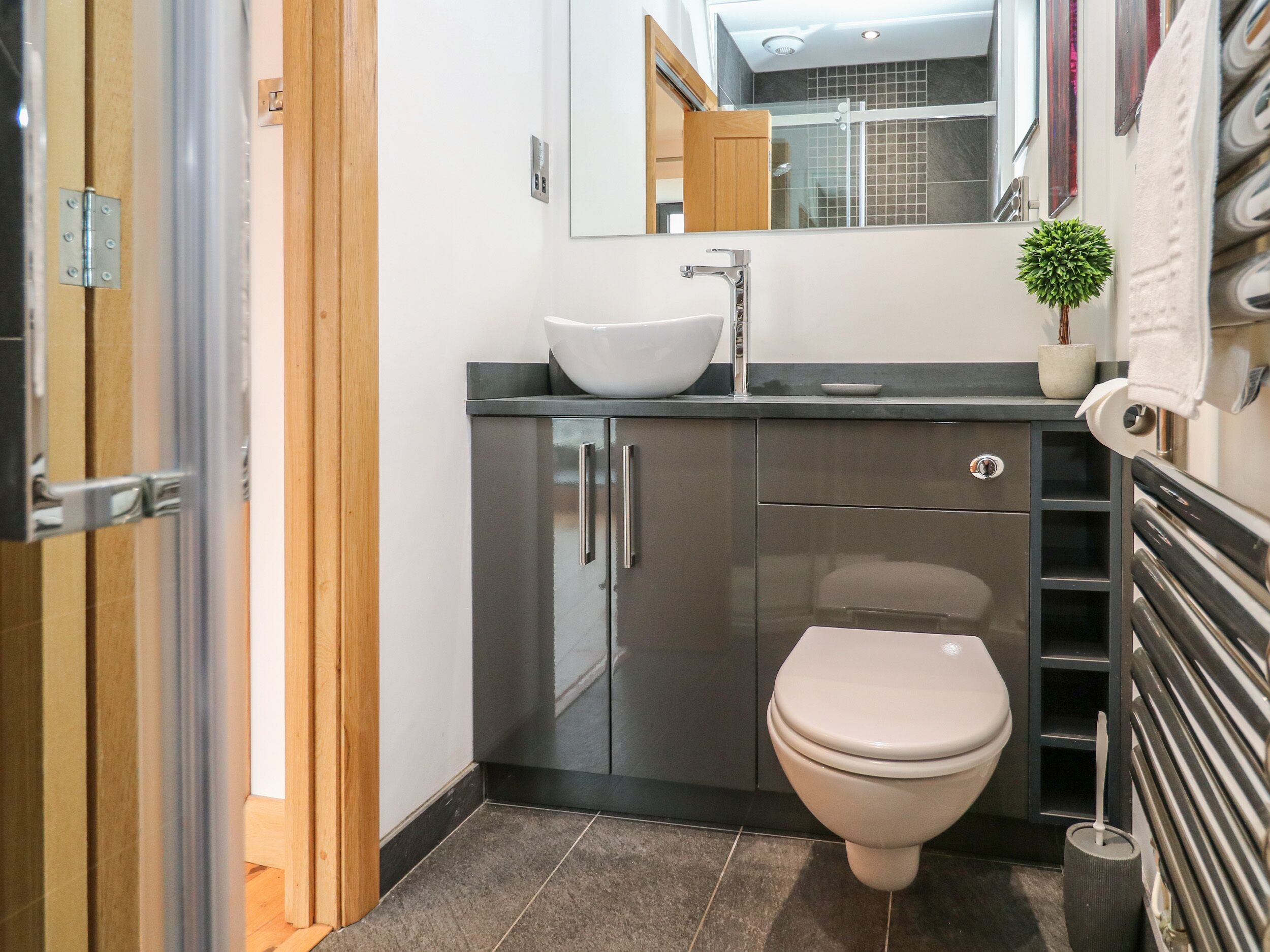 A modern bathroom with a toilet, sink, and shower.