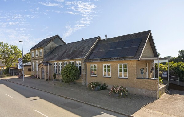 A two-story building with a traditional architectural style, featuring a pitched roof and brick construction.
