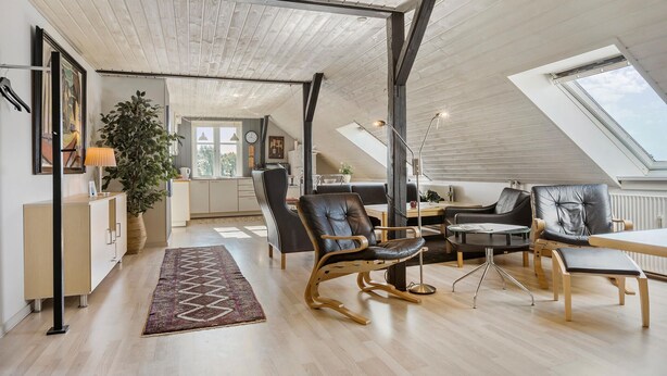 Un loft spacieux avec de hauts plafonds, un coin repas et une cuisine.