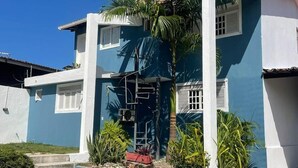 A two-story house with a blue exterior, white trim, and a small balcony. - Pousada Encanto dos Mares (Natal)