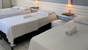 A hotel room with three beds, a white air conditioner, and bedside lamps. - Pousada Encanto dos Mares (Natal)