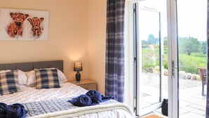 Un dormitorio con una cama, una mesita de noche, una lámpara y un cuadro de animales.