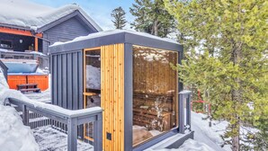 Une cabane avec un intérieur en bois, un balcon et une vue sur un paysage enneigé.