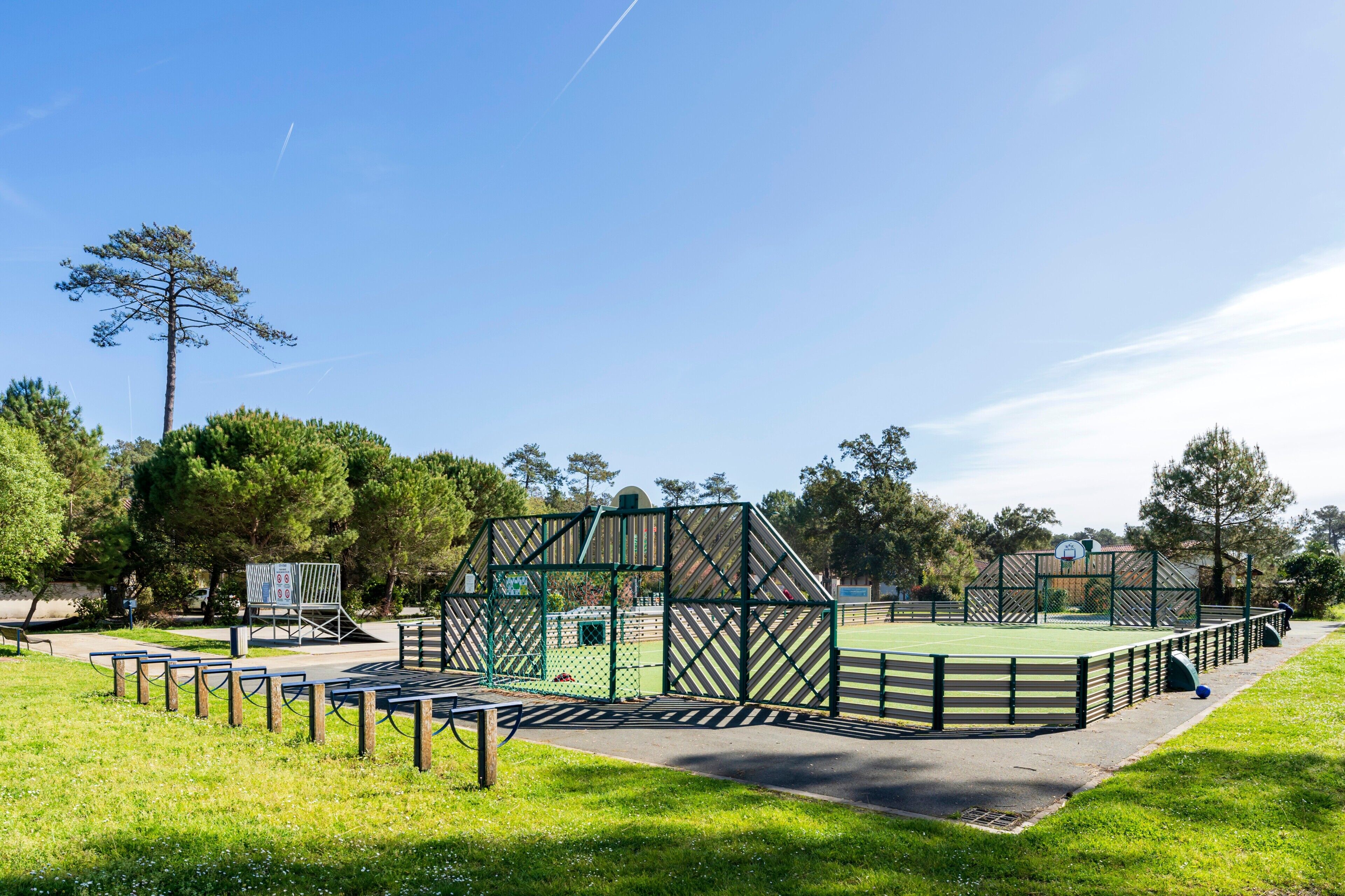 Una cancha deportiva con vallas de césped, madera y metal.
