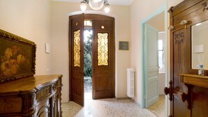 A room with a wooden door, a radiator, a framed picture, and a cabinet. - Apartment 'Appartamento In Villa La Baronessa' with Private Garden and Wi-Fi (Sanremo)