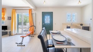 Eine moderne Küche mit Essbereich, einer Bank und Blick durch die Glastür.