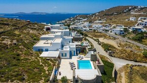 Un pueblo costero con edificios blancos, una piscina y una vista despejada del mar.