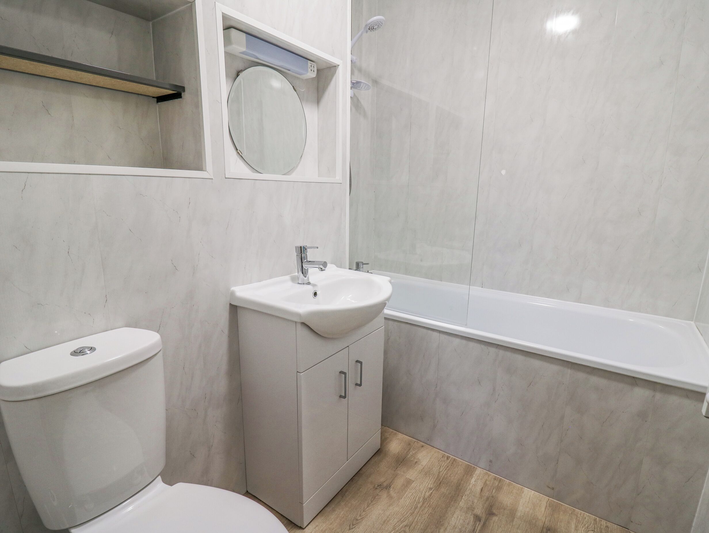 A bathroom with a toilet, sink, and bathtub.