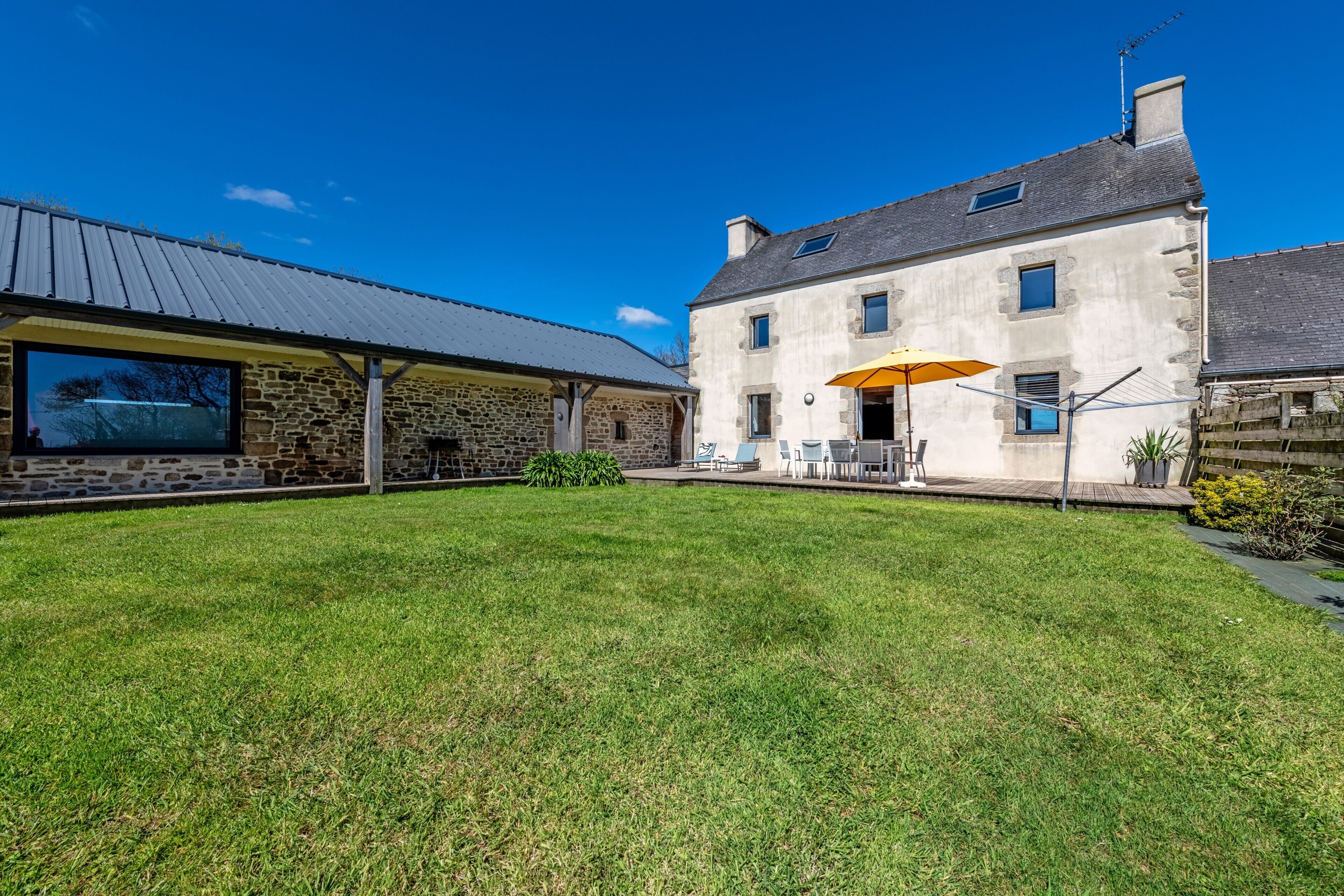 Un bâtiment en pierre doté d’une grande fenêtre et d’un patio couvert.