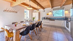 A modern kitchen with white cabinets, a large island, and stainless steel appliances. - Holiday Home with Private Heated Pool, Private Terrace, Garden and Wi-Fi (Plouguerneau)