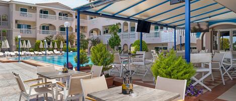 A poolside area with outdoor seating and a covered section.